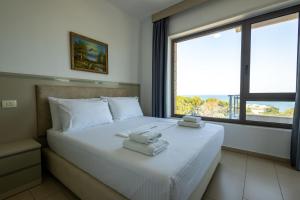 a bedroom with a bed with two towels on it at Britannia Resort & SPA in Vlorë +182 photos