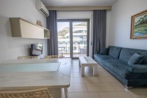 a living room with a blue couch and a table at Britannia Resort & SPA in Vlorë
