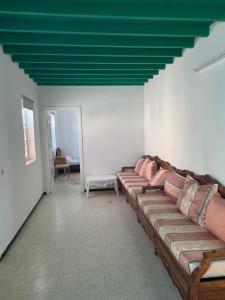 a living room with a couch and a green ceiling at Authentic, quiet and spacious house in El Guecheïne