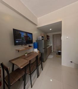 a dining room with a table and a refrigerator at Mactan Airport 1BR Resort with Pool in Mactan Island