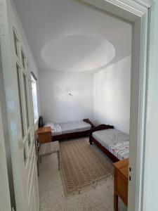 two beds in a small room with a hallway at Authentic, quiet and spacious house in El Guecheïne