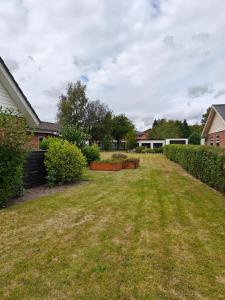 a yard with grass and bushes at Skolevænget 35 in Skjern
