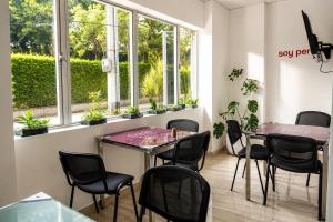 a room with a table and chairs and windows at Hotel Sixtina Plaza Medellin in Medellín