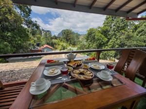 a table with food and drinks on a balcony at Lava Ella in Ella