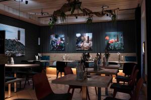 a restaurant with tables and chairs and paintings on the walls at Stadtplatz23 B&B in Bogen