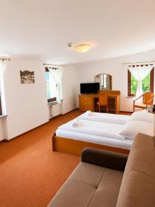 a bedroom with a large bed and a desk at Willa Agnieszki in Jagniątków