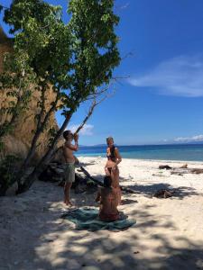 a group of people standing on a beach at Mangrove Reef Guest House in Airborei