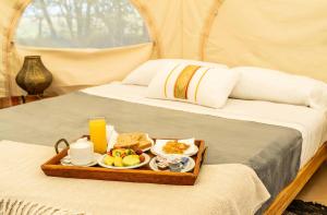 a tray of food on a bed in a tent at Terranova Glamping in Luján