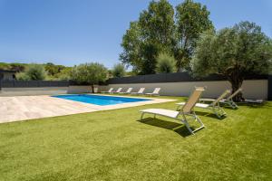 a group of chairs sitting next to a swimming pool at Modern Villa Olivera with Private Pool in Calella de Palafrugell