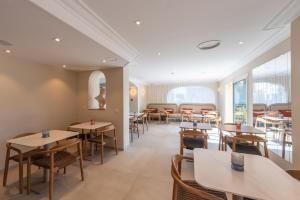 a restaurant with tables and chairs and windows at Le Petit Prince in Sainte-Maxime