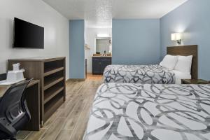 a hotel room with two beds and a flat screen tv at Americas Best Value Inn Weatherford in Weatherford