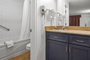 a bathroom with a sink and a hairdryer at Americas Best Value Inn Weatherford in Weatherford +22 photos