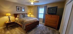 a bedroom with a bed and a television and a dresser at Charming Country Cottage in Murfreesboro