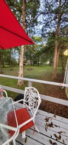 a red umbrella and a chair on a porch at Charming Country Cottage in Murfreesboro