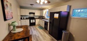 a kitchen with a black refrigerator and a wooden table at Charming Country Cottage in Murfreesboro