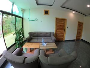 a living room with a couch and a table and chairs at Snow Land Hotel and Restaurant in Malam Jabba
