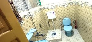 a bathroom with a blue toilet and a sink at Snow Land Hotel and Restaurant in Malam Jabba