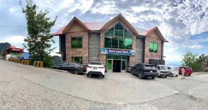 a building with cars parked in a parking lot at Snow Land Hotel and Restaurant in Malam Jabba