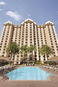 a large hotel with a swimming pool and palm trees at Signia by Hilton San Jose in San Jose