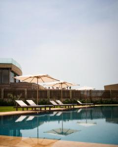 a swimming pool with chairs and umbrellas at The Riad by Blue Waves in Agadir