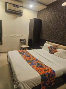 a bedroom with a bed with a colorful blanket on it at Crown Hotel Aadoree - Near Mumbai Airport, BKC Visa Consultant , Jio Convention Centre in Mumbai +4 photos