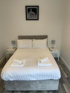 a bedroom with a bed with two towels on it at Elder Park Apartments in Glasgow