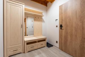 a dressing room with a mirror and a wooden door at Apartmány Jezerné in Velké Karlovice +64 photos