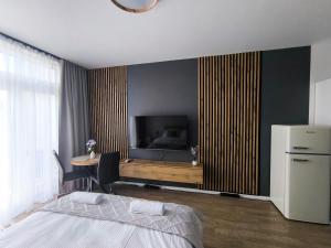 a bedroom with a bed and a television and a table at DN Fly & Stay in Wrocław
