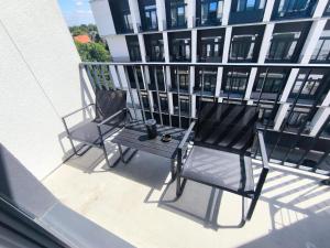 two chairs and a table on the balcony of a building at DN Fly & Stay in Wrocław