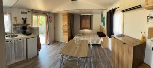 a room with a kitchen with a table and a bed at Le cocon & spa in Camaret-sur-Aigues