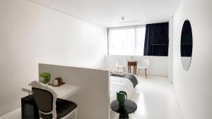 a white room with a bed and a table and chairs at Lokàl Boutique Hotel in Larnaca