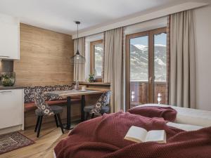 a hotel room with a kitchen and a table and chairs at Hotel Garni Larcherhof in Mayrhofen