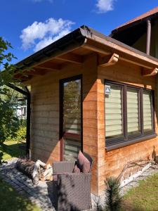 a log cabin with a window and chairs in front of it at Przy ścieżce in Węgierska Górka
