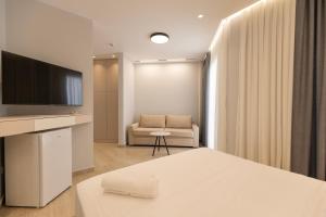 a living room with a couch and a television at Sirena Garden Resort in Tale