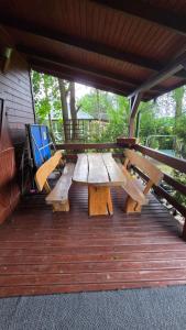 a picnic table and benches on a deck at Urokliwy domek Młynarze in Młynarze