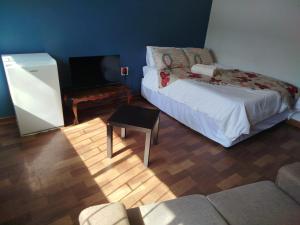 a living room with a bed and a tv at Manor Rentals in Potchefstroom
