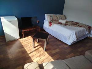 a living room with a bed and a tv at Manor Rentals in Potchefstroom