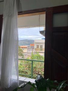 a window with a white curtain and a view at Quarto Manjericão in Ibicoara