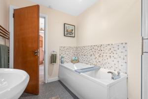 a white bathroom with a tub and a sink at The Nest in Belfast +55 photos