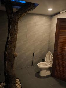 a bathroom with a toilet next to a tree at Bakesense home 01 in Ko Phangan