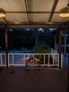 a wooden bench sitting on a deck with a railing at Bakesense home 01 in Ko Phangan