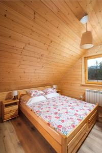 a bedroom with a bed in a wooden room at Chaty u Bibra in Sablówka