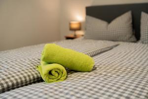 a green towel sitting on top of a bed at Gasthaus Stoiber in Buchbach
