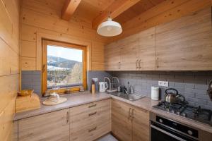 a kitchen with wooden cabinets and a window in a cabin at Chaty u Bibra in Sablówka