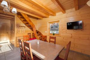 a dining room with a table and a flat screen tv at Chaty u Bibra in Sablówka