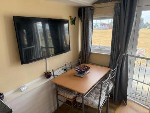 a table and chairs in a room with a window at The Butterfly in Leysdown-on-Sea