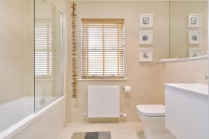 a bathroom with a toilet and a shower and a sink at Westview in St. Andrews +10 photos