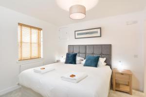 a bedroom with a large white bed with blue pillows at Westview in St. Andrews