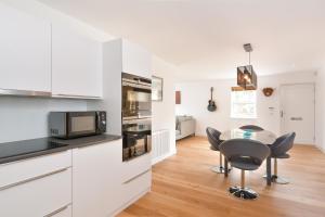a kitchen with white cabinets and a table and chairs at Westview in St. Andrews