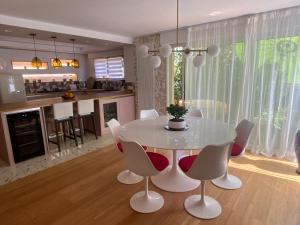 a dining room and kitchen with a white table and chairs at Le Cap Saint Jacques Chambre d hôtes proche de bayeux à 15 mn idéal plages du débarquement in Putot-en-Bessin